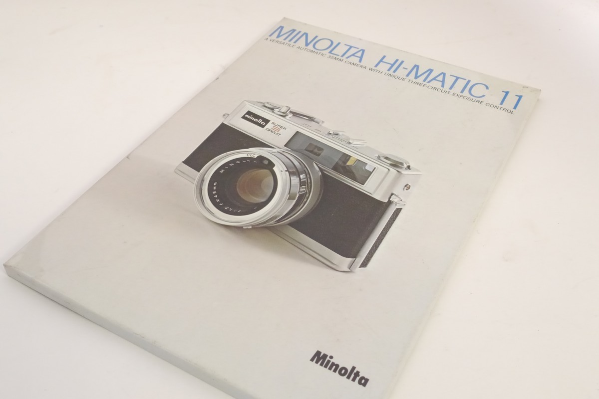 Minolta Hi-Matic 11 - A Versatile Automatic 35mm Camera with Unique Three-circuit Exposure Control metal Advertising display stand with hanging clip Minolta Hi-Matic 11 - A Versatile Automatic 35mm Camera with Unique Three-circuit Exposure Control metal Advertising display stand with hanging clip. 295 x 205mm