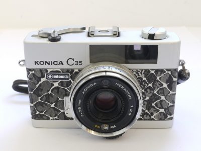 Konica C35 35mm coupled rangefinder camera with 38mm f2.8 Hexanon lens & wrist strap. Re-skinned with faux snakeskin covering