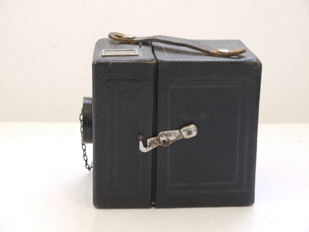 mwclassiccameras-20210716-274 Kodak Six-20 Brownie Junior leatherette covered Box camera, all plain, with added side mounting sports finder & front cap on a chain with metallic Art-Deco patterned front c1934-42. No handle