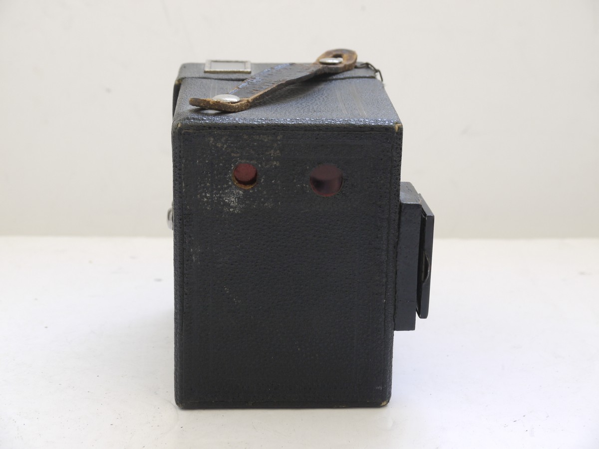 mwclassiccameras-20210716-275 Kodak Six-20 Brownie Junior leatherette covered Box camera, all plain, with added side mounting sports finder & front cap on a chain with metallic Art-Deco patterned front c1934-42. No handle