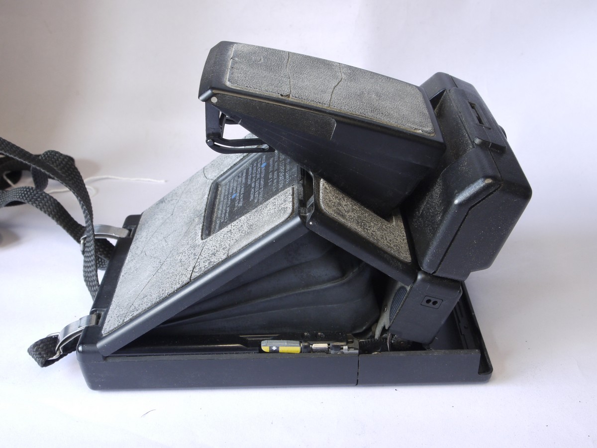 mwclassiccameras-20220729-268 Polaroid SX-70SE Sonar Onestep folding polaroid land camera with strap, flash bar, strap, "The artist at work" card, instructions & kodak case. Also with 3-image special effects filter for the Polaroid Impulse camera. THE PROPERTY OF THE LATE BERYL REID, ACTRESS (But no Provenance available - bought at auction of her possessions