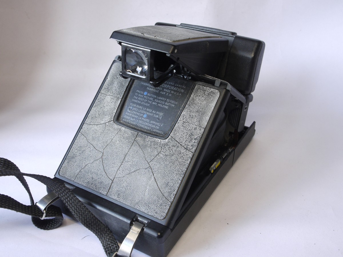 mwclassiccameras-20220729-269 Polaroid SX-70SE Sonar Onestep folding polaroid land camera with strap, flash bar, strap, "The artist at work" card, instructions & kodak case. Also with 3-image special effects filter for the Polaroid Impulse camera. THE PROPERTY OF THE LATE BERYL REID, ACTRESS (But no Provenance available - bought at auction of her possessions