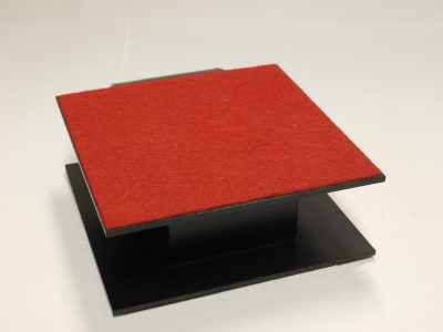Pentax Black plastic Display Stand, Square shaped with Red felt top & curved front. 120mm x 120mm x 43mm