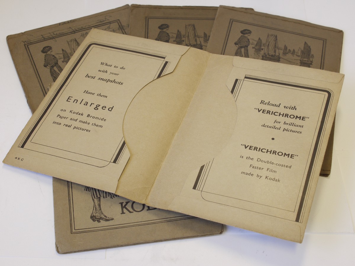 mwclassiccameras-20230526-322 Kodak Film Wallets - set of Five antique paper/card wallets for negatives, four with front images of woman by lake/ocean & one of woman holding eaerly bellows camera