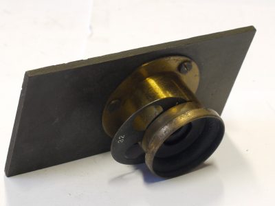 Unamed 1 1/2 -2 inch (Estimated) brass lens with rotating wheel aperture, flange & metal panel (Panel is 100 x 52mm)