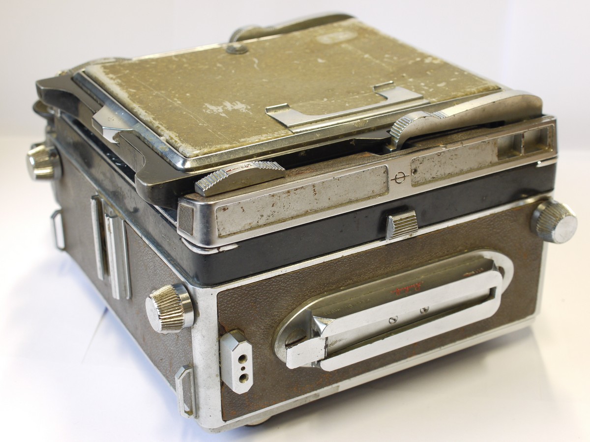 mwclassiccameras-20231117-45 Linhof Technika 5x4 coupled rangefinder camera with brown covering & with 135mm rangefinder cam. Has revolcing back, rear xtension, front movements & base lowers downwards
