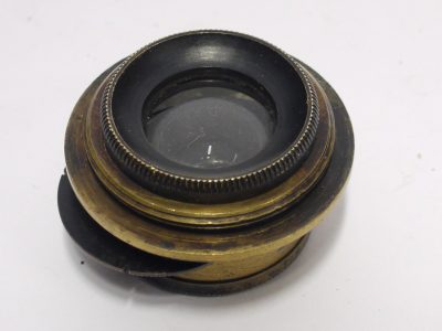 Unamed 5 inch (Estimated) small brass lens with rotating wheel apertures & rear screw mount. Glass diameter is 15mm