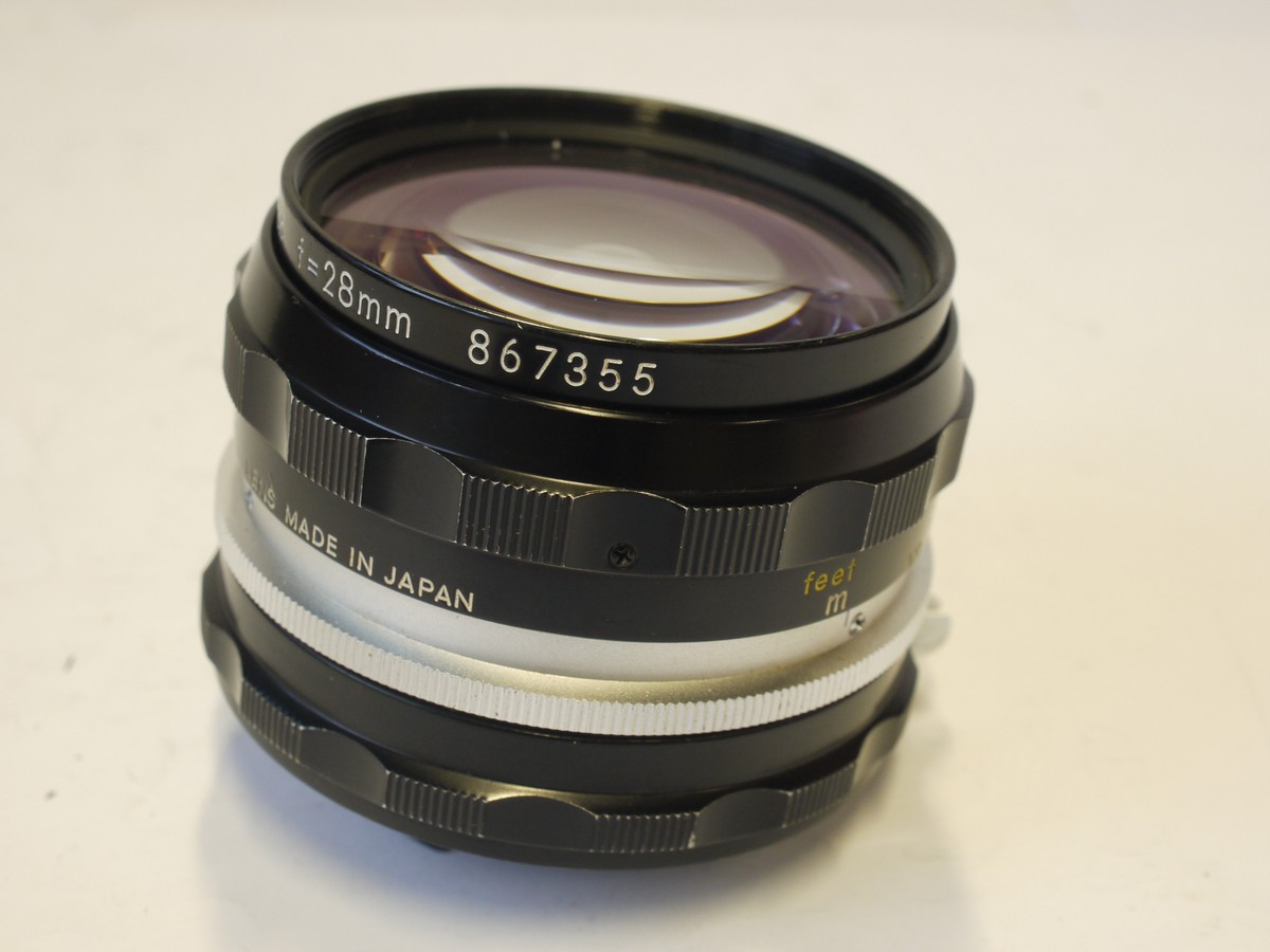 mwclassiccameras-20240308-148 Nikon 28mm f3.5 Nikkor-H.C PRE-AI lens with scalloped focusing ring + Nikon caps & Nikon Box with packaging
