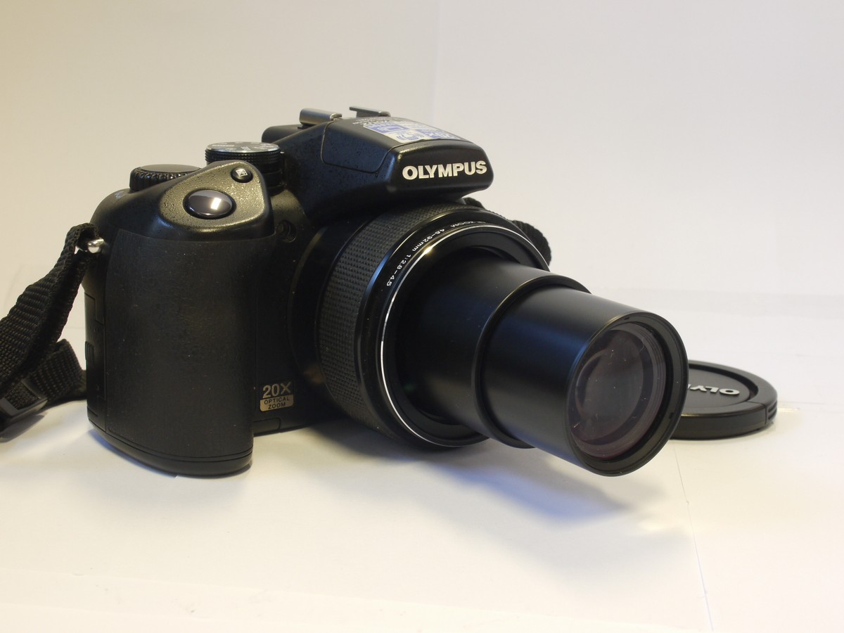 mwclassiccameras-20240315-97 Olympus SP-57OUZ 10 MP Bridge Camera, black, with 4.6-92mm f2.8-4.5 ED AFZoom lens + front cap, neck strap & case. Takes AA Batteries