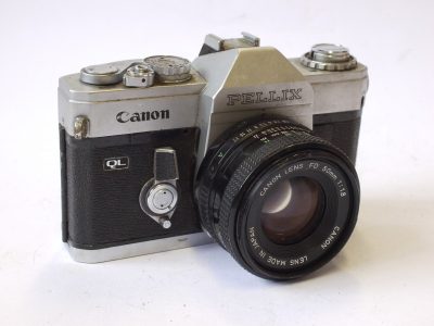 Canon Pellix QL 35mm SLR, chrome + Canon 50mm f1.8 FD lens. Features through-the-mirror mechanism with mirror not rising when taking pictures. FOR RESTORATION/SPARE PARTS