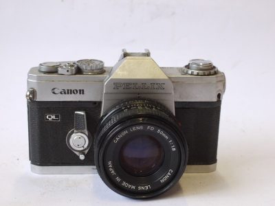Canon Pellix QL 35mm SLR, chrome + Canon 50mm f1.8 FD lens. Features through-the-mirror mechanism with mirror not rising when taking pictures. FOR RESTORATION/SPARE PARTS