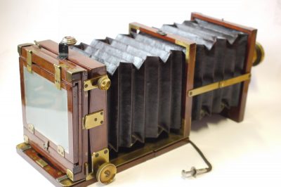 Meagher Improved Portable Bellows 1/4 plate tailboard camera, mahogany & brass with Red Bellows + Thornton Pickard roller-blind shutter & Dallmeyer f8 Rapid Rectilinear brass lens with  Iris Diaphragm, engraved "6x5" (coverage). With ground glass back & double plate holder. Front furthr extends with single strut locking into place. UNCOMMON