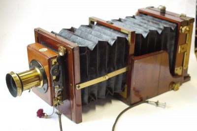Meagher Improved Portable Bellows 1/4 plate tailboard camera, mahogany & brass with Red Bellows + Thornton Pickard roller-blind shutter & Dallmeyer f8 Rapid Rectilinear brass lens with  Iris Diaphragm, engraved "6x5" (coverage). With ground glass back & double plate holder. Front furthr extends with single strut locking into place. UNCOMMON