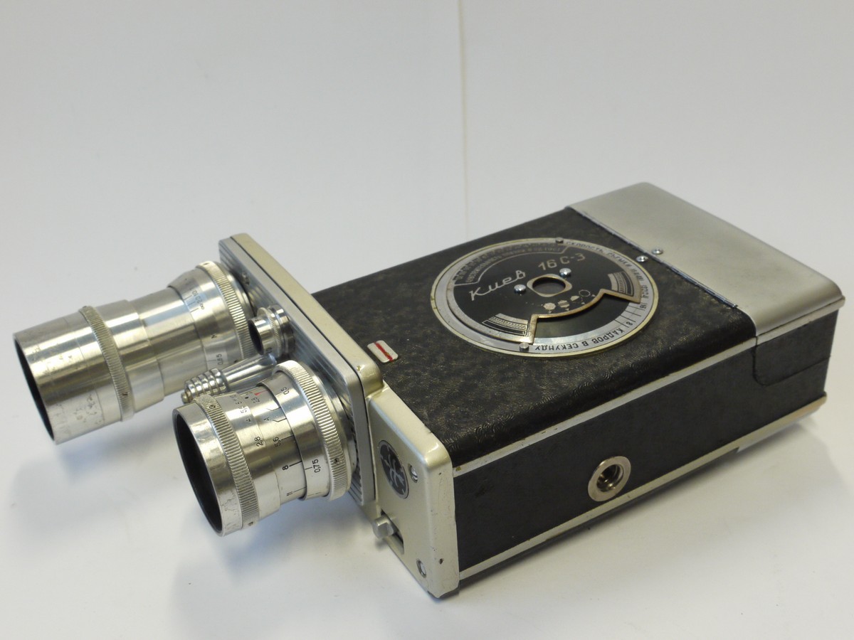 mwclassiccameras-20241108-283 Kiev 16C-3 16mm Spring Motored Cine camera (taking Drop-in 16mm Catridge film) with 20mm f2.8 PO-51 & 50mm f3.5 Industar-50 C mount lens on a Trin-Turret + Two Film Cartridges, Pistol Grip & Outfit case. UNCOMMON