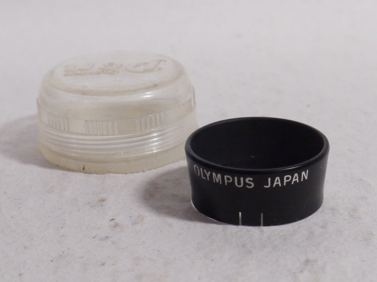 mwclassiccameras-20250117-121 Olympus Pen 25.5mm push-on black metal lens hood for Pen Half-Frame compact cameras + Olympus keeper case. UNCOMMON