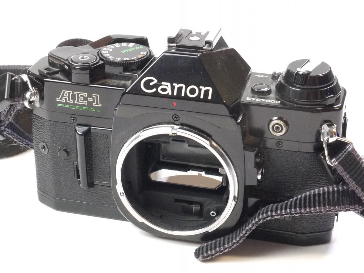 mwclassiccameras-20250418-84 Canon AE-1 Program 35mm SLR body, black + Canon Neck Strap. NEEDS REPAIR