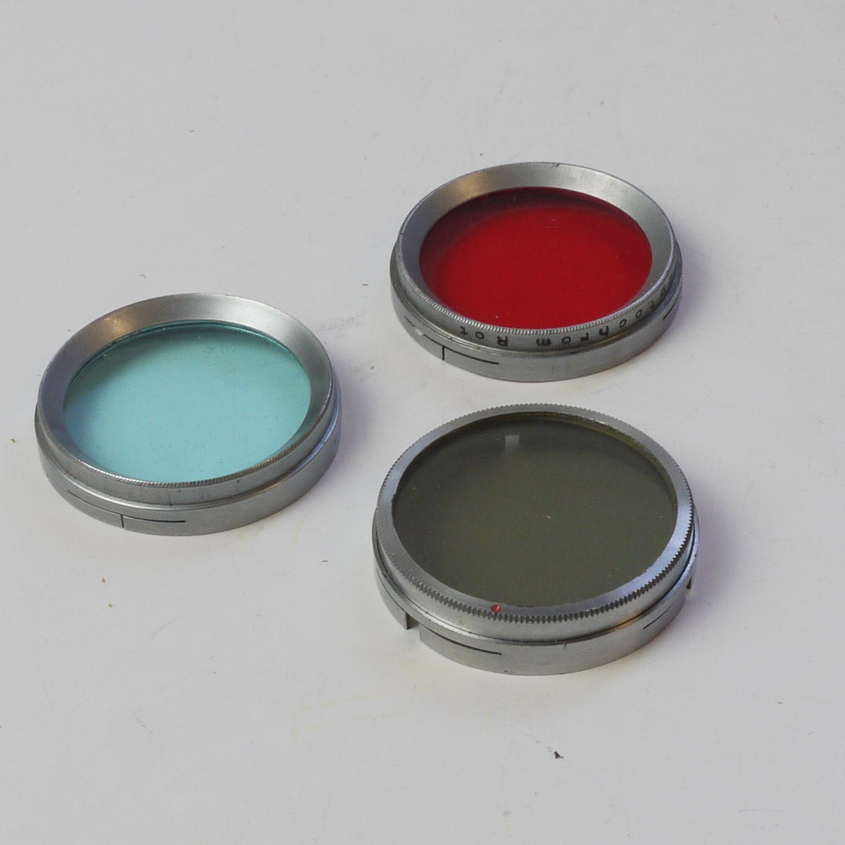 mwclassiccameras-20250613-195 Set of Three A36 Push-On Filters (Unbranded Neutral Density, Optochrom Blue & Optochrom Red). All chrome rim, copies of the Leitz A36 filters