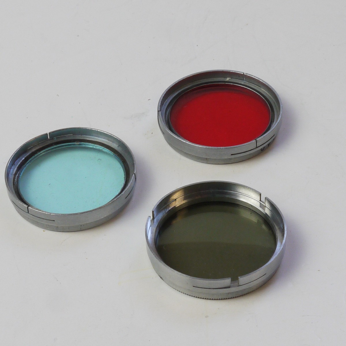 mwclassiccameras-20250613-196 Set of Three A36 Push-On Filters (Unbranded Neutral Density, Optochrom Blue & Optochrom Red). All chrome rim, copies of the Leitz A36 filters