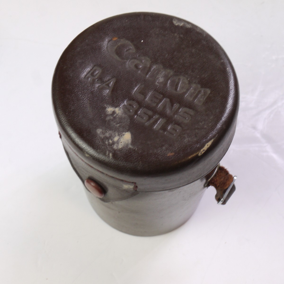 mwclassiccameras-20250620-203 Canon Hard leather bound brown lens case, marked on the top for the "Canon 85mm f1.9 R-A" (75mm x 110mm)