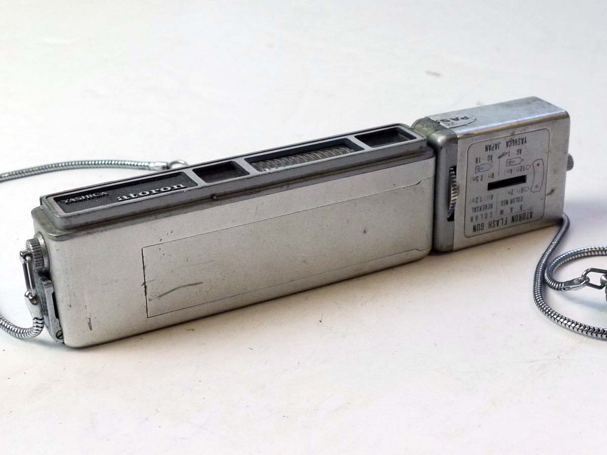 mwclassiccameras-20250801-182 Yashica Atoron Subminiature Camera, chrome, with side mounting Yashica Atoron Flash Gun & Chain Strap with notches for aiding distance measurement