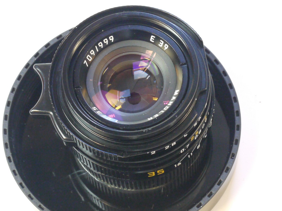 mwclassiccameras-20250829-203 Mandler 35mm f2 "Summi-Cron-M" 7-Element Black lens, Limited Production (430 out of 999) based on the Leica 35mm f2 Summicron-M lens. A Well-Regarded, Quality-made lens with very nice bokeh, Made in China in Leica M mount + Unbranded Clip-on Metal lens hood with vents (Copy of Leitz Hooid), Mandler E39 UVa filter, black rim, Unbranded Clip-on plastic lens hood (marked 12526) Mandler front cap, Rear lens cap, Hood/filter Box, keeper case & main Box with packaging & outer box.