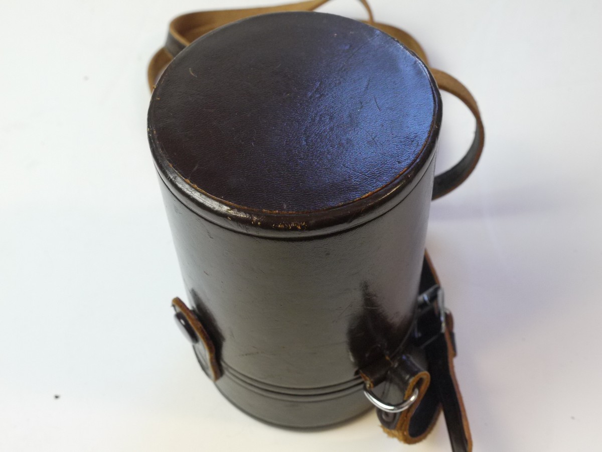 mwclassiccameras-20250829-211 Nikon brown leather lens case, marked "Nikkor" on top, with strap & with red felt inlay. 138 x 83mm