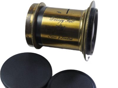 Derogy No.3 Brass lens (Estimated 10 inch focal length) with Slot for Waterhouse Stops (No Stops included). With flange. Height is 60mm. Diameter is 45mm